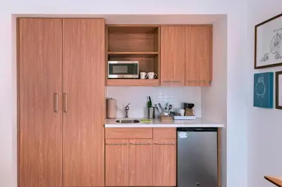 a kitchen with wooden cabinets and a microwave at Element Palmdale in Palmdale