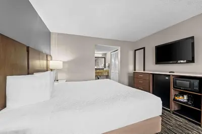 a hotel room with a bed and a flat screen tv at Best Western Los Alamitos Inn & Suites in Los Alamitos