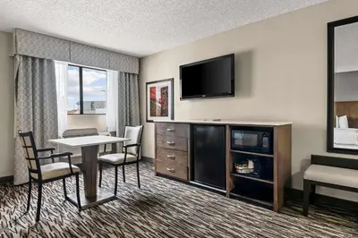 a hotel room with a table and chairs and a television at Best Western Los Alamitos Inn & Suites in Los Alamitos