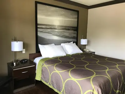 a hotel room with a bed with a large picture on the wall at Skyways Hotel in Los Angeles