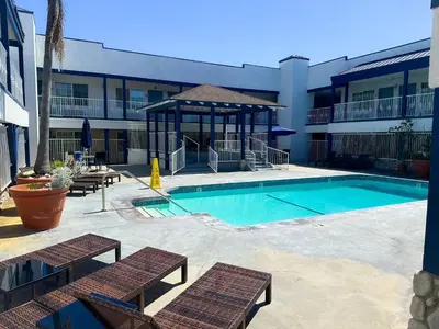a swimming pool with a gazebo next to a building at Wave Hotel Manhattan Beach in Manhattan Beach