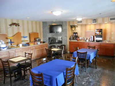 a restaurant with blue tables and chairs and a kitchen at Wave Hotel Manhattan Beach in Manhattan Beach