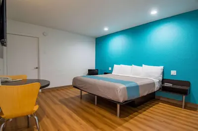 a bedroom with a bed with a blue wall at Motel 6-San Bernardino, CA - Downtown in San Bernardino
