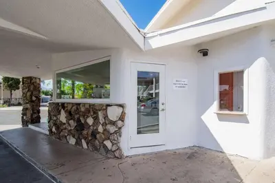 a building with a white door and a pile of fire wood at Motel 6-San Bernardino, CA - Downtown in San Bernardino