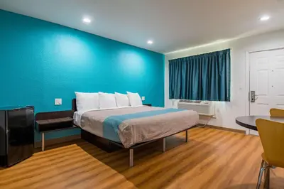 a room with a bed and a blue wall at Motel 6-San Bernardino, CA - Downtown in San Bernardino