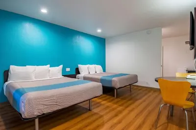 a room with two beds and a blue wall at Motel 6-San Bernardino, CA - Downtown in San Bernardino