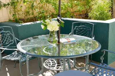 a glass table with a vase of flowers on it at Gateway Hotel Santa Monica in Los Angeles