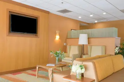 a waiting room with a couch and a tv at Gateway Hotel Santa Monica in Los Angeles
