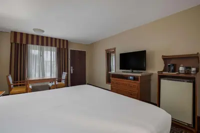 a hotel room with a bed and a flat screen tv at Best Western Norwalk Inn in Norwalk