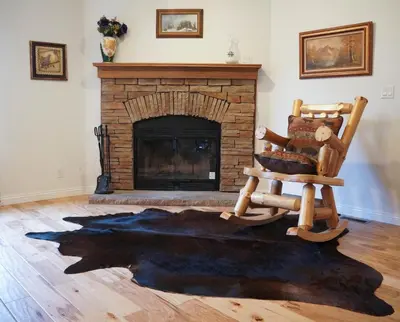 a rocking chair in a living room with a fireplace at Country Club Chalet in Big Bear City