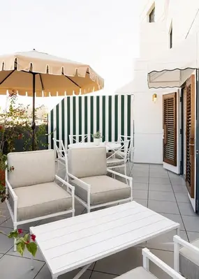 a patio with two chairs and an umbrella at Palihouse West Hollywood at Beverly Hills in Los Angeles