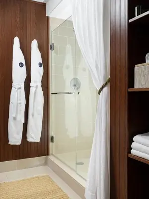 a bathroom with a shower with white robes at Palihouse West Hollywood at Beverly Hills in Los Angeles