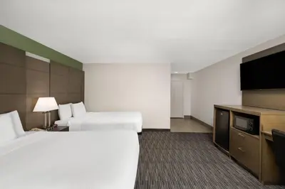 a hotel room with two beds and a flat screen tv at Travelodge Inn & Suites by Wyndham Anaheim on Disneyland Dr in Anaheim