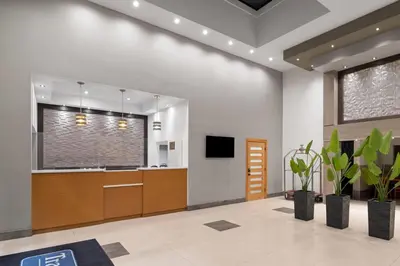 an office lobby with a reception desk and plants at Travelodge Inn & Suites by Wyndham Anaheim on Disneyland Dr in Anaheim