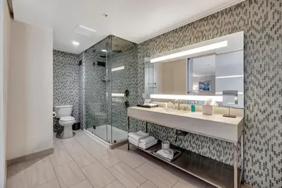a bathroom with a shower and a sink and a mirror at Ocean View Hotel in Los Angeles