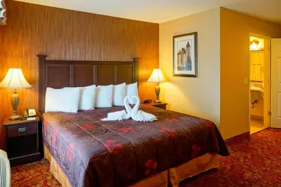 a hotel room with a bed with a ribbon on it at Castle Inn and Suites Anaheim in Anaheim
