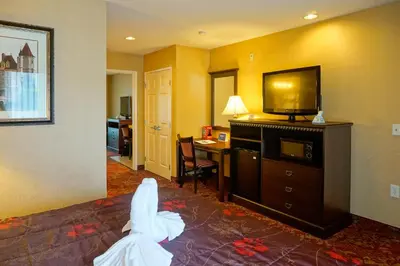 a hotel room with a bed with a flat screen tv at Castle Inn and Suites Anaheim in Anaheim