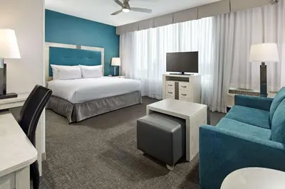 a hotel room with a bed and a couch and a tv at Homewood Suites By Hilton Long Beach Airport in Long Beach