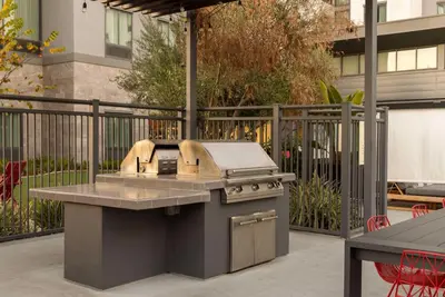 a outdoor kitchen with a grill on a patio at Homewood Suites By Hilton Long Beach Airport in Long Beach