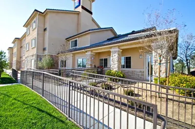 a fence in front of a house at Studio 6-Bakersfield, CA in Bakersfield