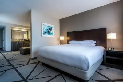 a hotel room with a large bed and a kitchen at DoubleTree by Hilton Los Angeles Norwalk in Norwalk