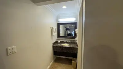 a bathroom with a sink and a mirror at Garden Inn and Suites Glendora in Glendora