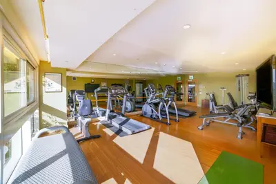 a gym with a lot of treadmills and ellipticals at Miyako Hybrid Hotel Torrance in Torrance