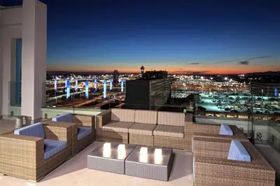 a rooftop patio with a view of a city at night at H Hotel Los Angeles, Curio Collection By Hilton in Los Angeles