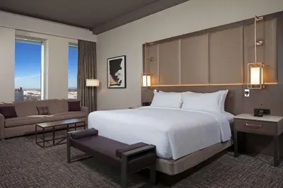 a hotel room with a large bed and a couch at H Hotel Los Angeles, Curio Collection By Hilton in Los Angeles