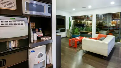 a living room with a couch and a microwave at The Tangerine - a Burbank Hotel in Burbank