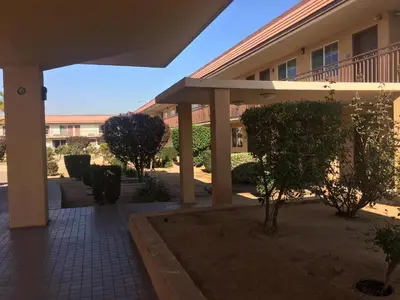 a courtyard of a building with trees and bushes at Budget Lodge San Bernardino in San Bernardino