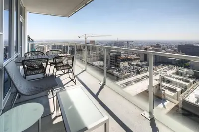 a balcony with chairs and tables on a building at Luxurious Highrise 2b 2b Apartment Heart Of Downtown LA in Los Angeles
