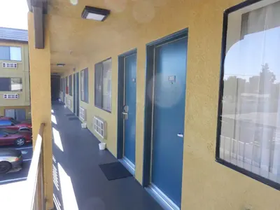 an empty hallway of a building with blue doors at Simply Home Inn & Suites - Riverside in Riverside