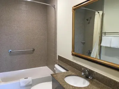 a bathroom with a sink and a toilet and a mirror at Simply Home Inn & Suites - Riverside in Riverside