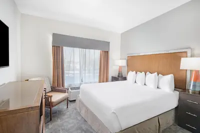 a hotel room with a large bed and a desk at Ramada by Wyndham Bakersfield in Bakersfield