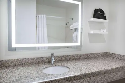 a bathroom with a sink and a mirror at Ramada by Wyndham Bakersfield in Bakersfield