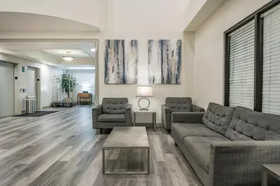 a living room with two couches and a table at Ramada by Wyndham Bakersfield in Bakersfield