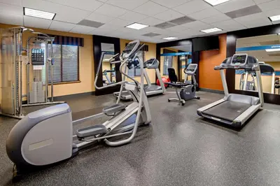 a gym with several treadmills and elliptical machines at Hampton Inn and Suites Bakersfield / Highway 58 in Bakersfield