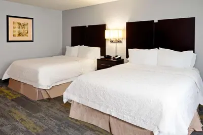 two beds in a hotel room with white sheets at Hampton Inn and Suites Bakersfield / Highway 58 in Bakersfield