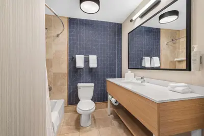 a bathroom with a toilet and a sink and a mirror at Spark by Hilton Bakersfield Central in Bakersfield
