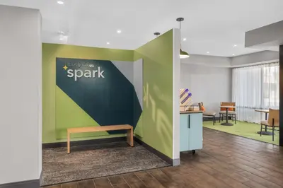a bench in a room with a green wall at Spark by Hilton Bakersfield Central in Bakersfield