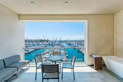 a balcony with a table and chairs and a view of a harbor at Shade Hotel Redondo Beach in Redondo Beach