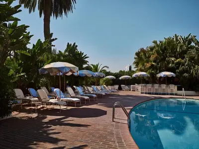 a group of chairs and umbrellas next to a swimming pool at Chateau Marmont in Los Angeles