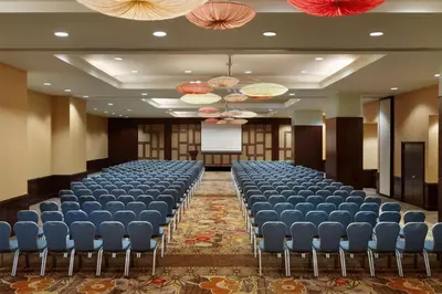 a conference room with a row of chairs and a screen at Embassy Suites Los Angeles Glendale in Glendale