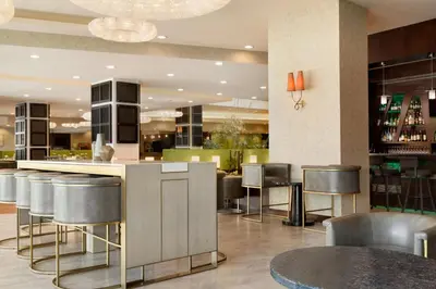 a restaurant with a bar with stools at Embassy Suites Los Angeles Glendale in Glendale
