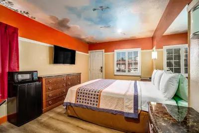 a bedroom with a bed and a flat screen tv at Geneva Motel in Inglewood