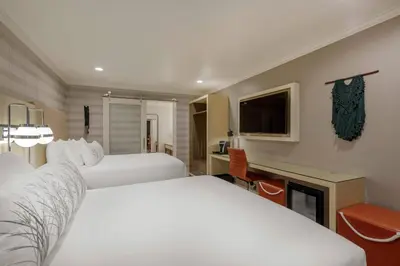 a hotel room with two beds and a fireplace at Bluestem Hotel Torrance Los Angeles, an Ascend Collection Hotel in Torrance