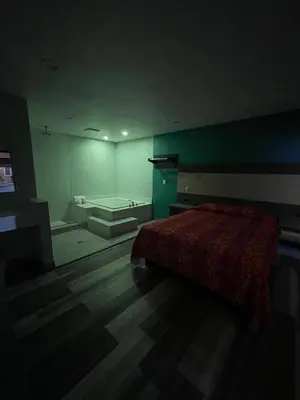 a dark room with a bed and a tub in it at Casa Bell Motel, Los Angeles - LAX Airport in Inglewood