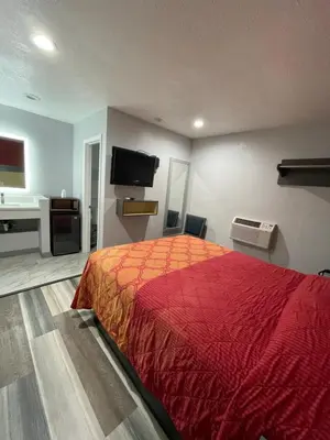 a bedroom with a red bed and a television at Casa Bell Motel, Los Angeles - LAX Airport in Inglewood