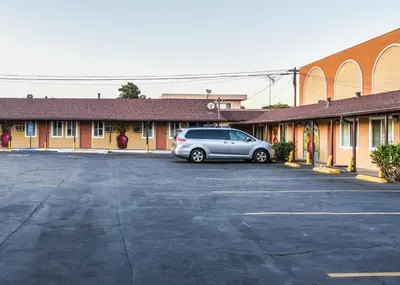 a car parked in a parking lot in front of a building at Casa Bell Motel, Los Angeles - LAX Airport in Inglewood